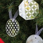 Use white glitter and Mod Podge Rocks stencils to make these pretty and simple DIY ornaments out of mirrors.