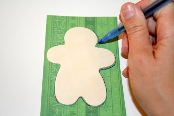 Tracing a gingerbread shape on paper with a pen