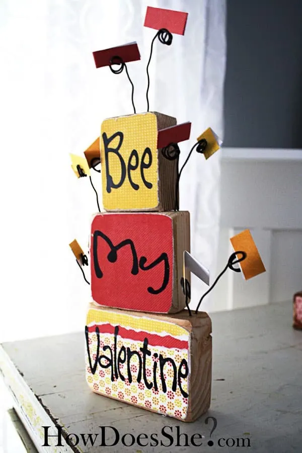 Leave sweet messages for your family with this DIY valentine display, built with scrap wood and decorated with pretty papers and Mod Podge.