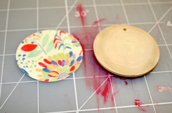 Cut out paper circle next to a wood pendant