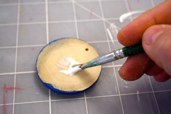 Applying Mod Podge to the top of the pendant with a paintbrush