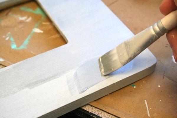 Painting a frame with silver sterling paint using a paintbrush