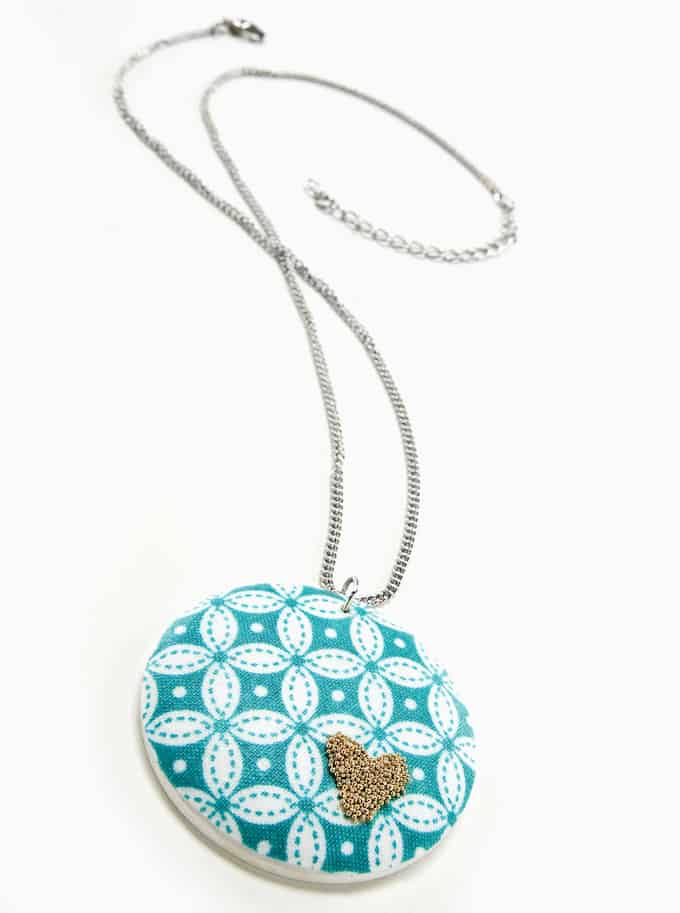 This beaded heart DIY necklace combines two unlikely colors - aqua and gold - with Mod Podge and microbeads for a unique jewelry look.