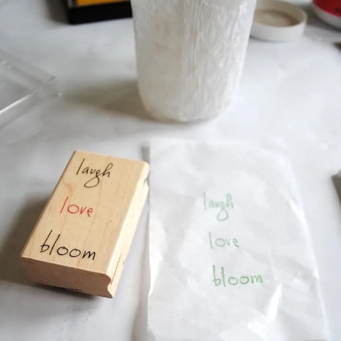 Laugh, love, and bloom stamped on a piece of tissue paper