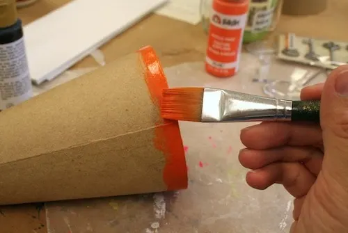 Painting a paper cone with orange paint