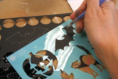 Tracing a bat using a stencil, on a black piece of cardstock