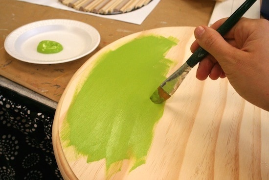 Painting a plaque with green acrylic paint