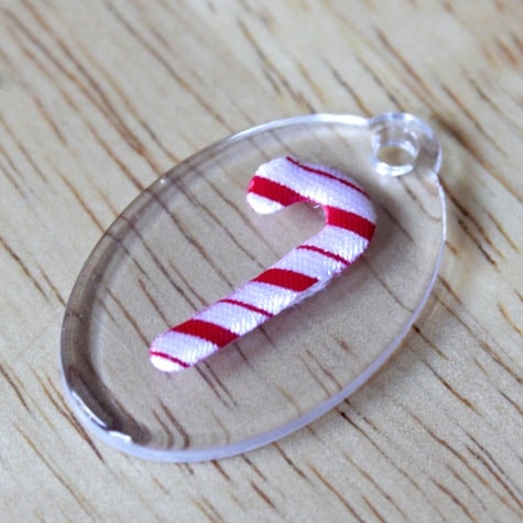 Mini candy cane on top of an acrylic oval