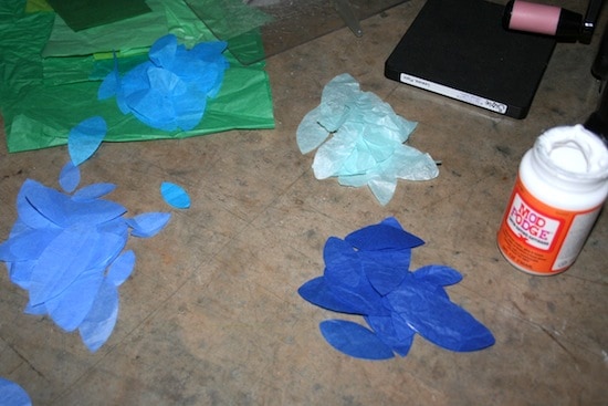 Three colors of tissue paper leaves and a bottle of Mod Podge Satin