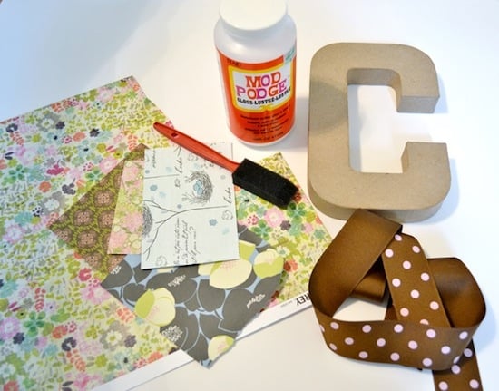 Scrapbook paper, foam brush, Mod Podge Gloss, a paper mache letter, and ribbon