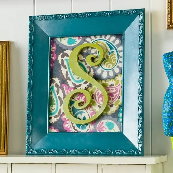 Create personalized initial wall art with an old budget frame, fabric and Mod Podge. I added Mod Podge Pearlized Sealer for an extra special touch.