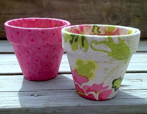 Use pretty fabric on these Mod Podge terra cotta pots for the perfect spring craft project! Makes a great container garden - or gift idea.