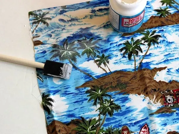 Placing a layer of Mod Podge on the front of some beachy fabric