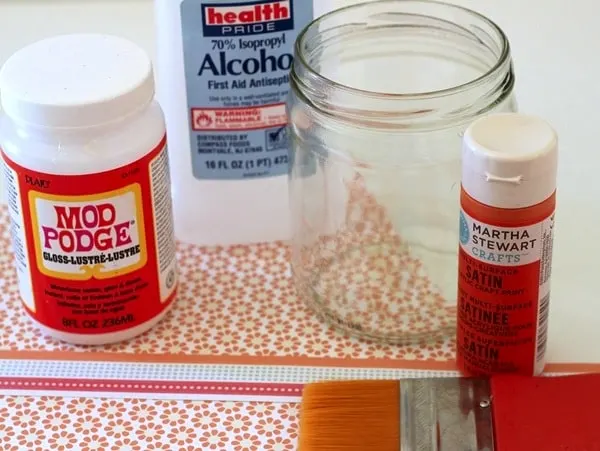 Glass jar, Mod Podge, scrapbook paper, craft paint, isopropyl alcohol, and a paintbrush