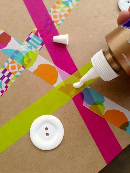 Gluing a button on top of washi tape on a paper mache box