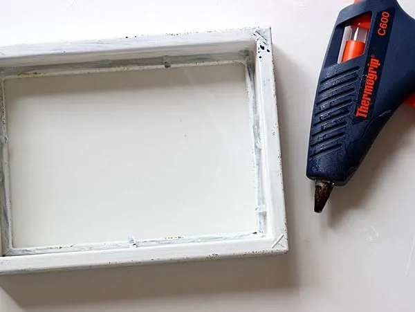 Hot glue the glass into the frame