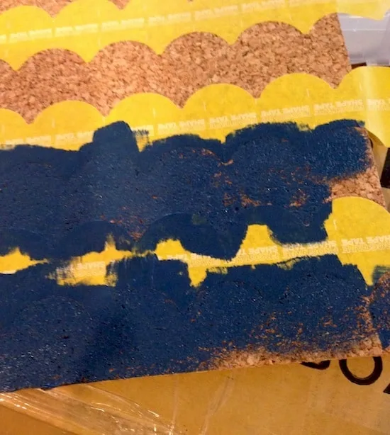 Painting the cork board with navy blue acrylic paint