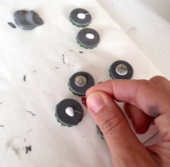 Gluing thumbtacks to the back of wood circles with craft glue