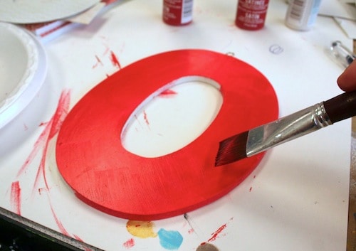 Painting a letter O with red paint