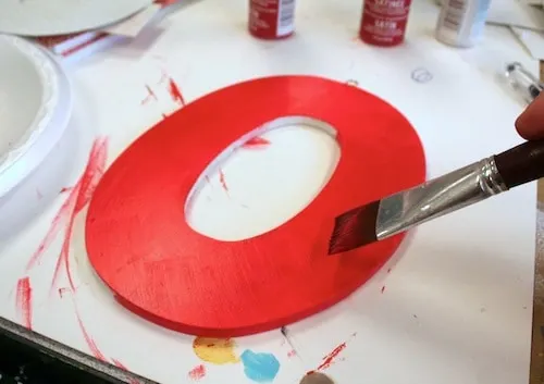 Painting a letter O with red paint