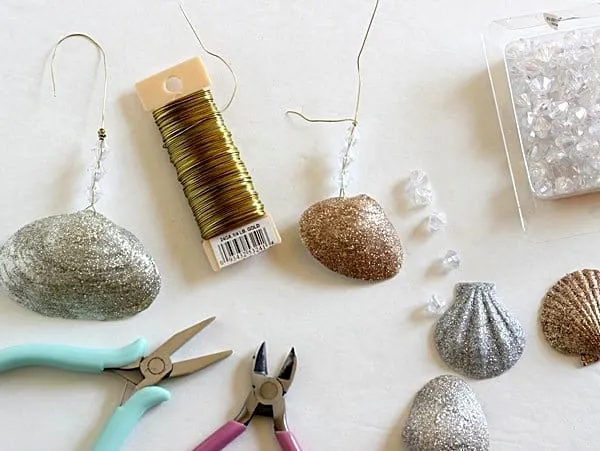 Make holiday decorations the easy way! This seashell ornaments DIY is so simple . . just use glitter and Mod Podge to make pretty Christmas decor.