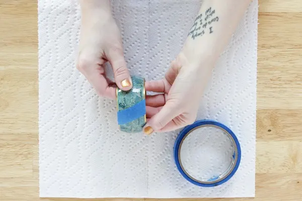 Applying painter's tape to a bangle before painting with Mod Podge