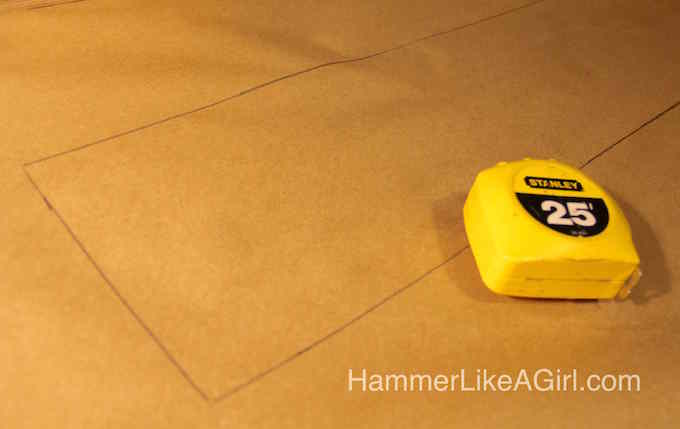 Rectangle drawn out on a brown piece of paper with a tape measure