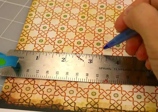 Tracing lines on scrapbook paper with a pen and ruler