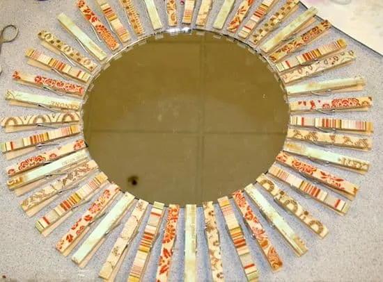 Clothespins laying around the perimeter of a mirror