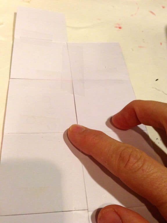 Using Scotch tape to piece together squares of scrapbook paper