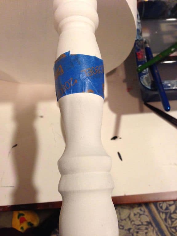Taping off the leg of a stool with blue painter's tape
