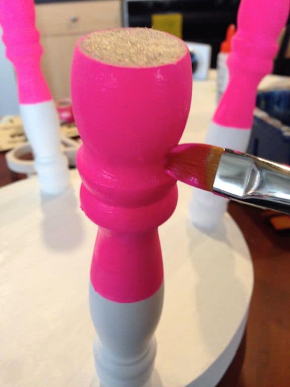 Stool leg being painted with neon pink paint