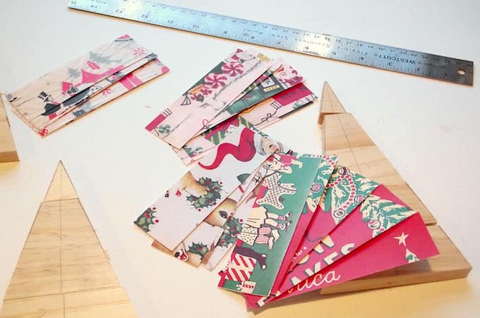 Wood Christmas trees and a pile of 2" vintage Christmas themed paper strips with a ruler
