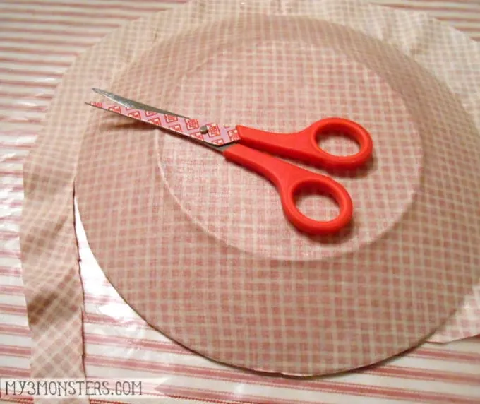 Trim the fabric around the edge of the plate with scissors
