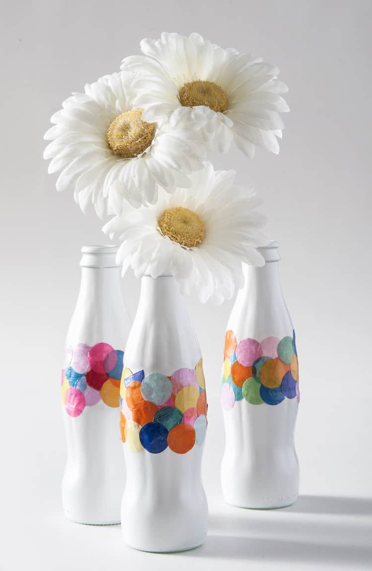 Recycle old Coke bottles into DIY confetti vases - all you need is a little bit of spray paint and Mod Podge. This craft is so easy!