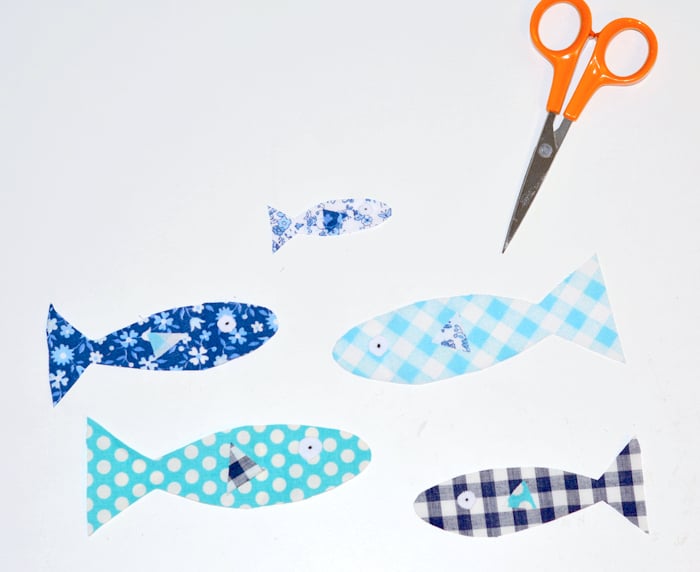 Fish shapes cut out of fabric with scissors