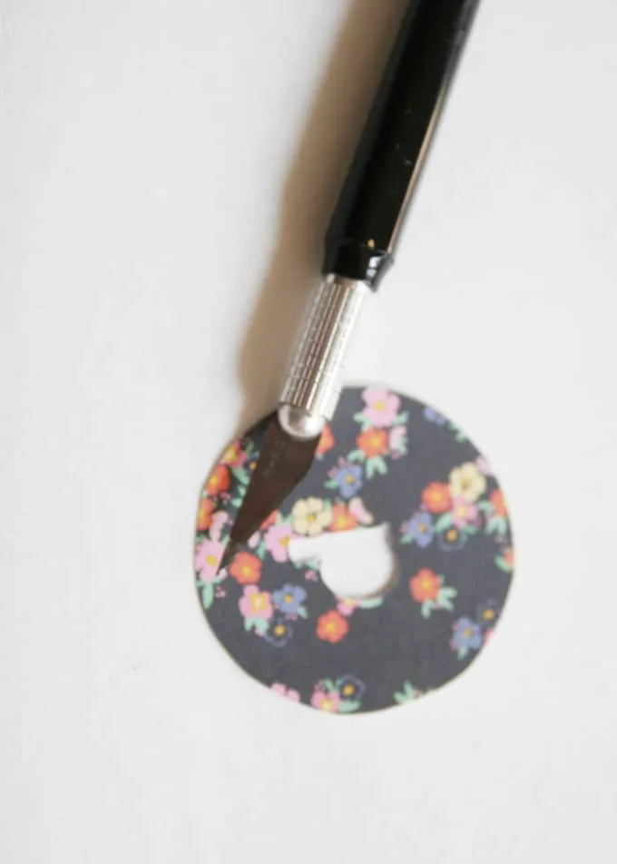 Cutting a letter out of a paper circle with a craft knife