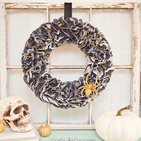 This Halloween wreath is so easy to make - it only takes about 30 minutes! Grab your cupcake liners, glitter, and Mod Podge. So festive!