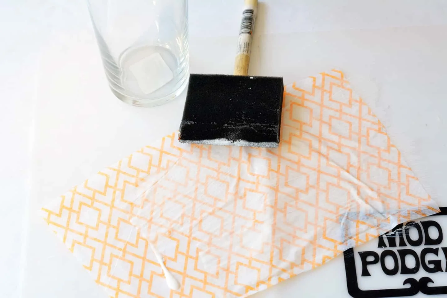 Add Mod Podge to tissue paper with a foam brush