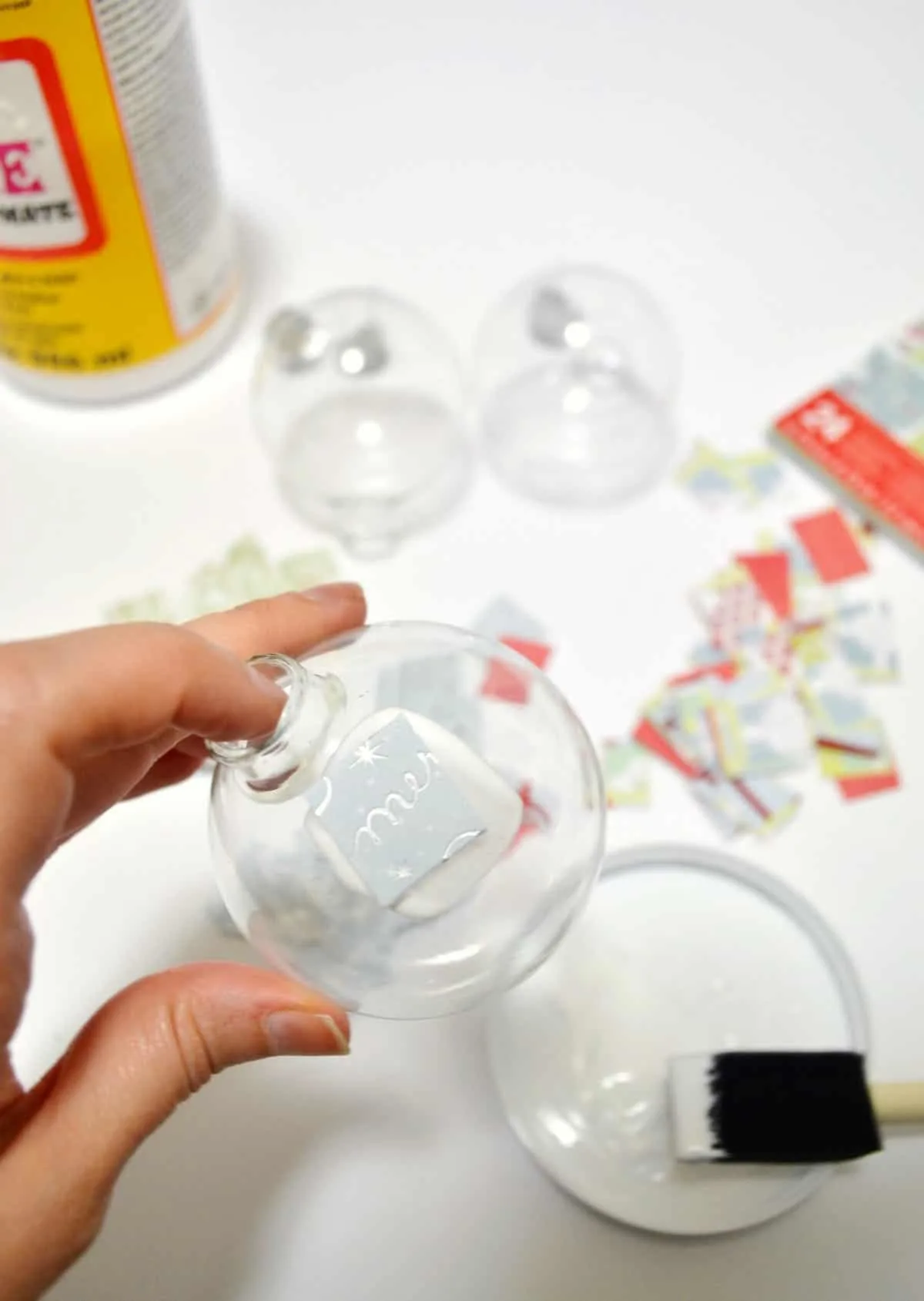 Mod Podge a piece of scrapbook paper to a clear glass ornament