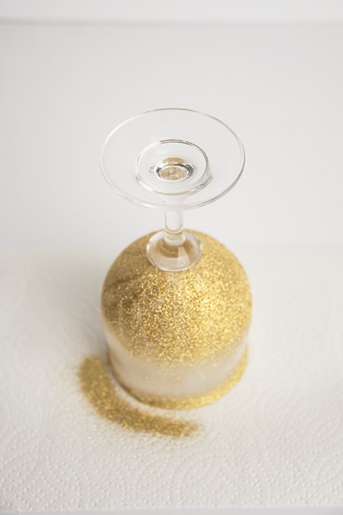 Wine glass sprinkled with glitter drying on a paper towel