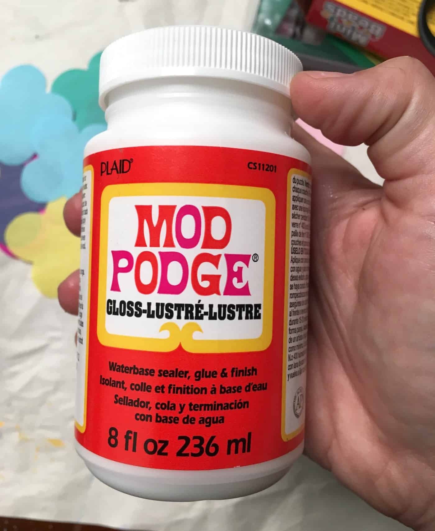 Hand holding a bottle of Mod Podge Gloss