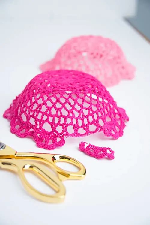 Trimming the edges of the doilies with a pair of scissors