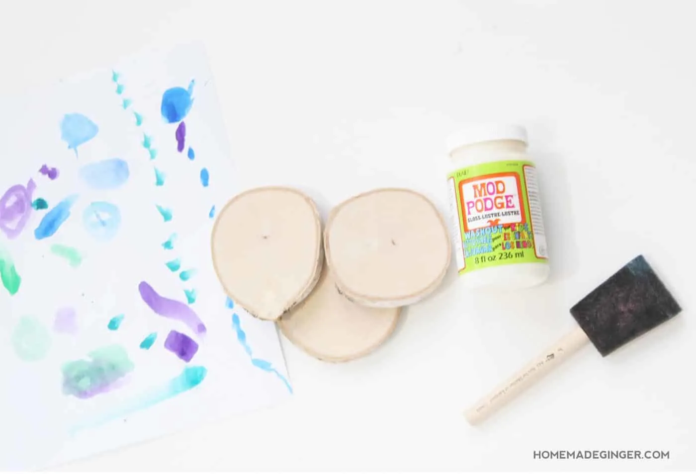 Kids paintings, wood slices, Mod Podge, and a foam brush