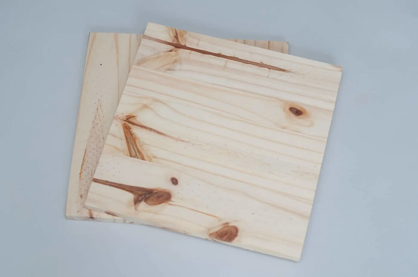 Two wood boards that are 12" square sitting on top of each other