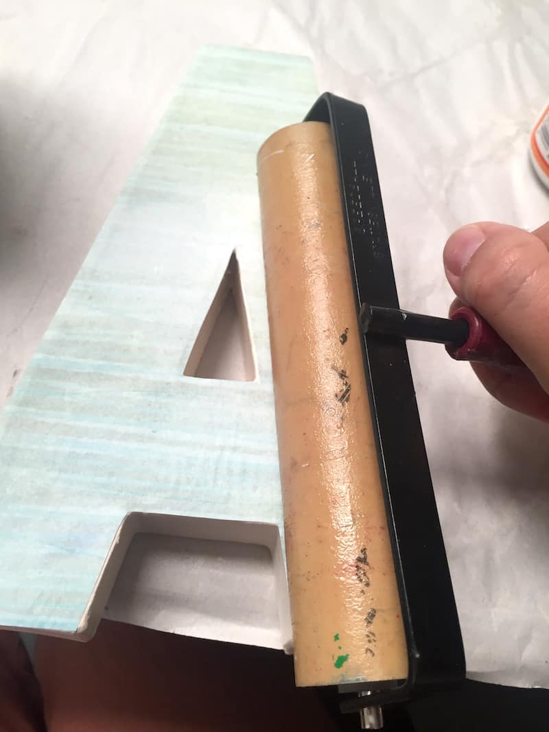 Rolling a brayer to smooth the paper down