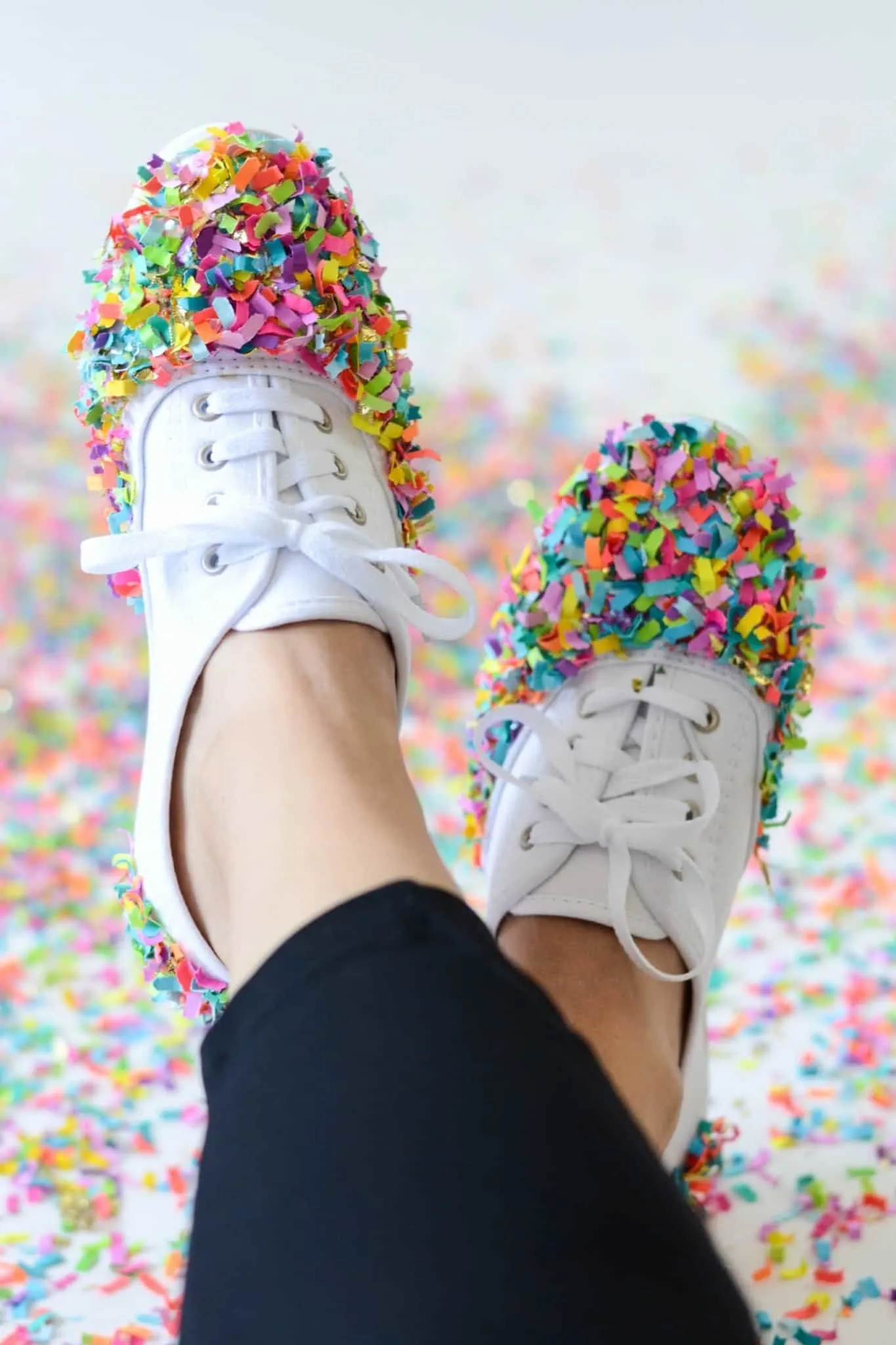 White shoes with colorful confetti covering the toes
