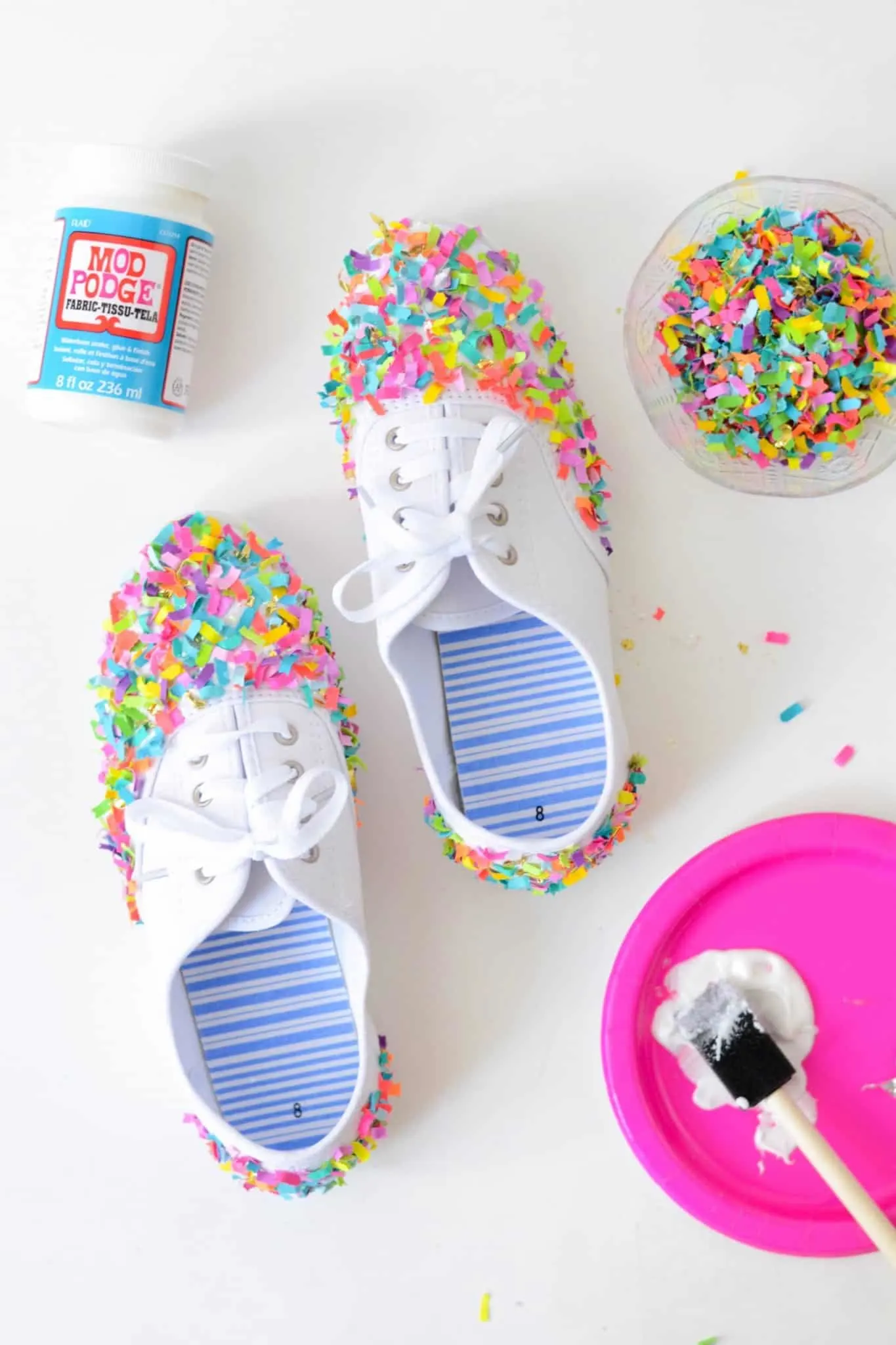 Applying confetti to shoes with Mod Podge