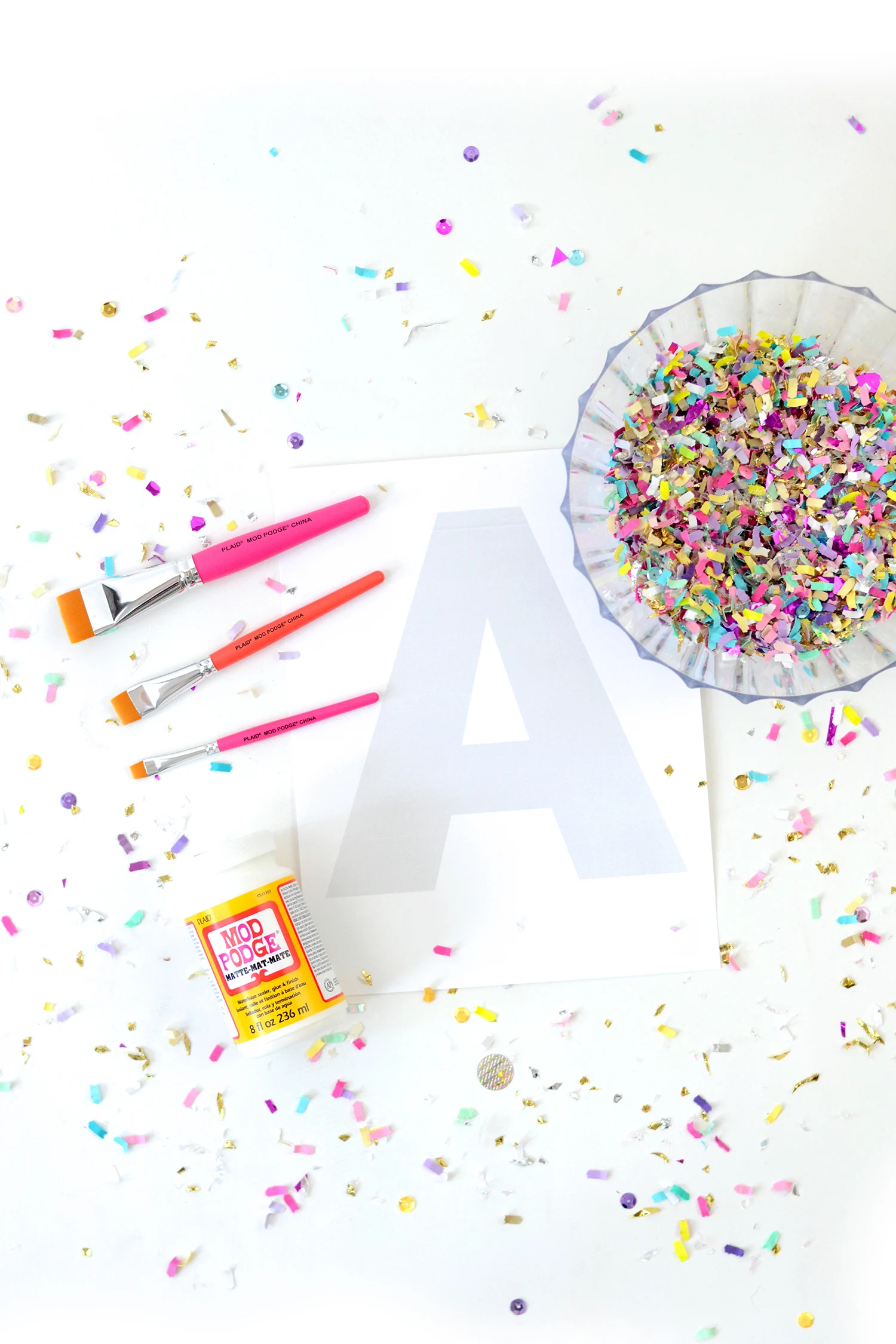 Paintbrushes, printed letters, and confetti