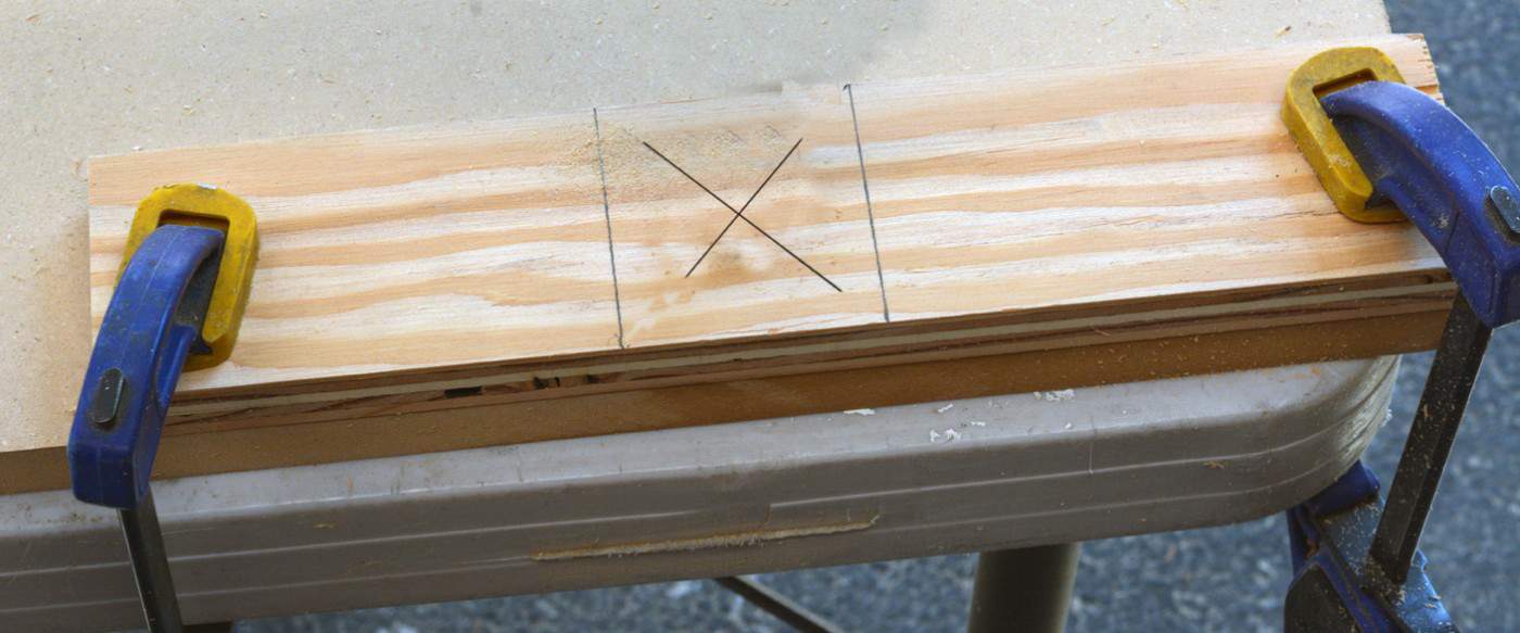 Wood clamped down to a table with clamps